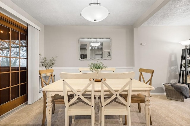 carpeted dining room featuring a textured ceiling