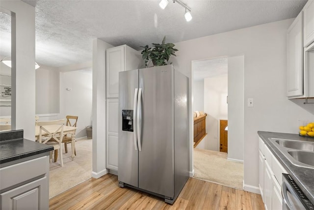 kitchen featuring white cabinetry, appliances with stainless steel finishes, light hardwood / wood-style floors, and sink