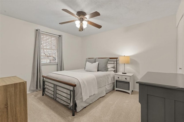 carpeted bedroom featuring ceiling fan and a textured ceiling