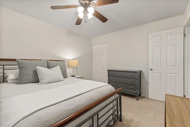 bedroom featuring ceiling fan, a closet, and light carpet