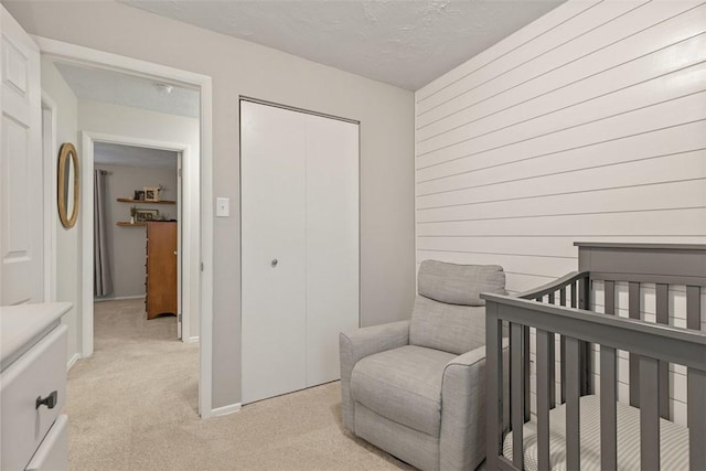 carpeted bedroom featuring a closet and a textured ceiling