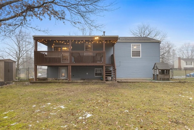 back of house with a storage unit, a deck, and a lawn