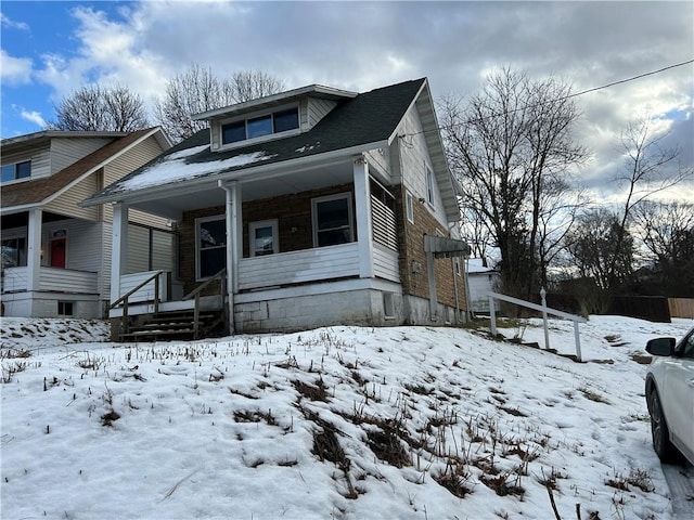 snow covered property with a porch