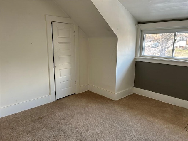 additional living space with lofted ceiling and carpet flooring