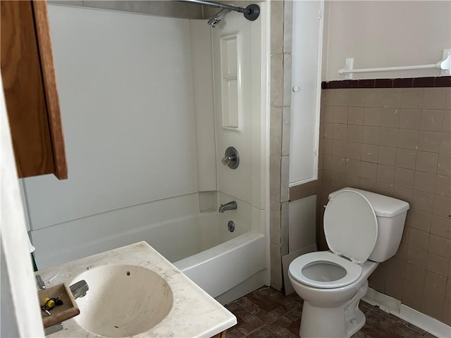 full bathroom with shower / bath combination, vanity, tile walls, and toilet