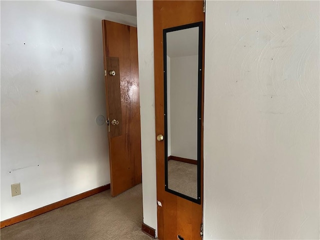 hallway featuring light colored carpet