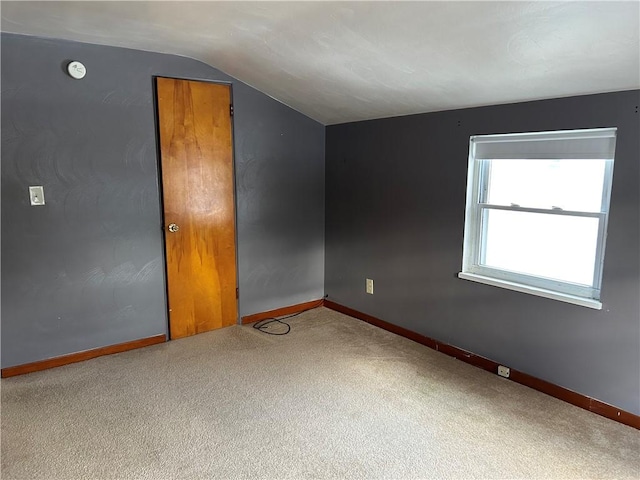 empty room with lofted ceiling and carpet