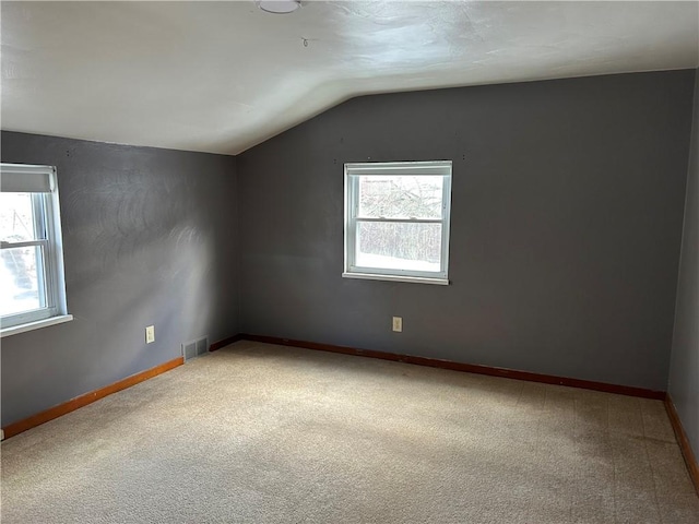 carpeted empty room featuring lofted ceiling