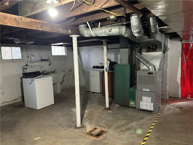 basement with separate washer and dryer, sink, and heating unit