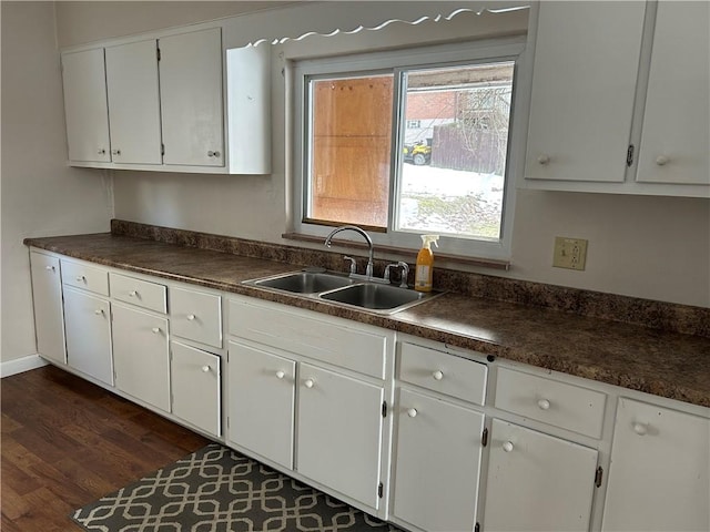 kitchen featuring dark hardwood / wood-style floors, sink, and white cabinets