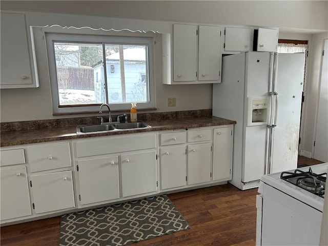 kitchen with white appliances, dark hardwood / wood-style flooring, sink, and white cabinets