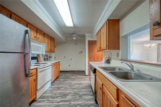 kitchen featuring sink, crown molding, stainless steel appliances, light hardwood / wood-style floors, and ceiling fan with notable chandelier