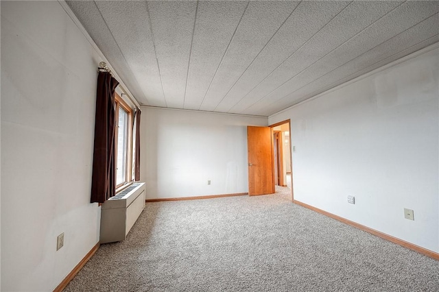 spare room with carpet floors and radiator heating unit