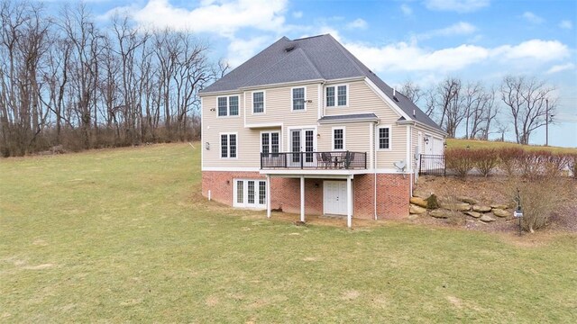 rear view of property featuring a wooden deck, a yard, and french doors