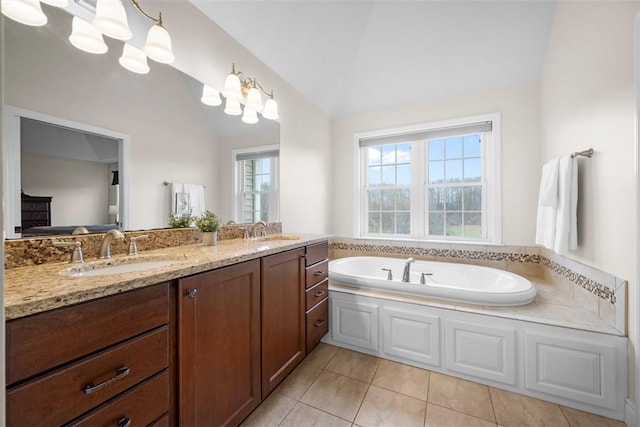 bathroom with a tub to relax in, lofted ceiling, tile patterned flooring, and vanity