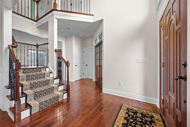 foyer entrance featuring dark hardwood / wood-style flooring and a high ceiling