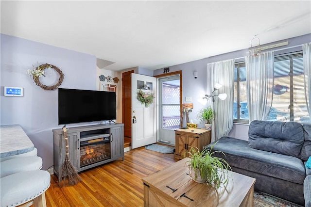 living room with a wealth of natural light and light hardwood / wood-style flooring