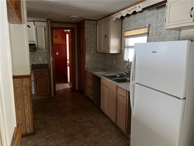 kitchen with sink, decorative backsplash, and white fridge