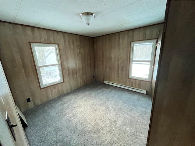 carpeted empty room with a baseboard radiator and wood walls