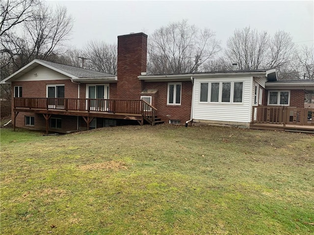 back of property featuring a wooden deck and a yard