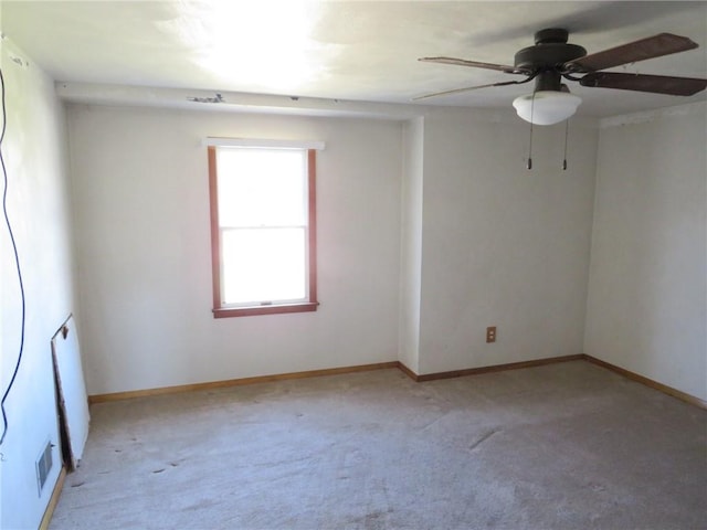 spare room with light colored carpet, visible vents, and baseboards