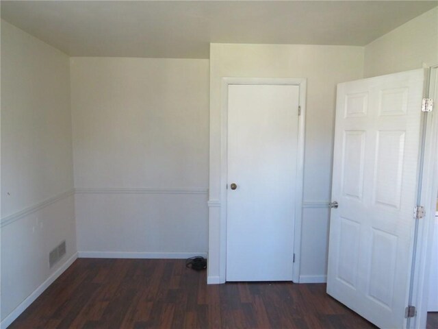 unfurnished bedroom featuring dark hardwood / wood-style flooring