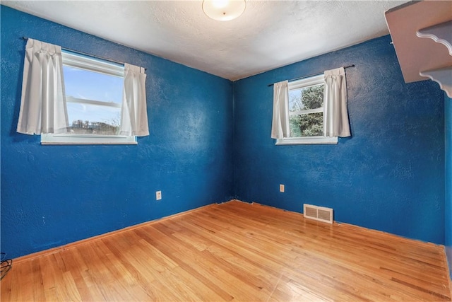 spare room with wood-type flooring and a textured ceiling