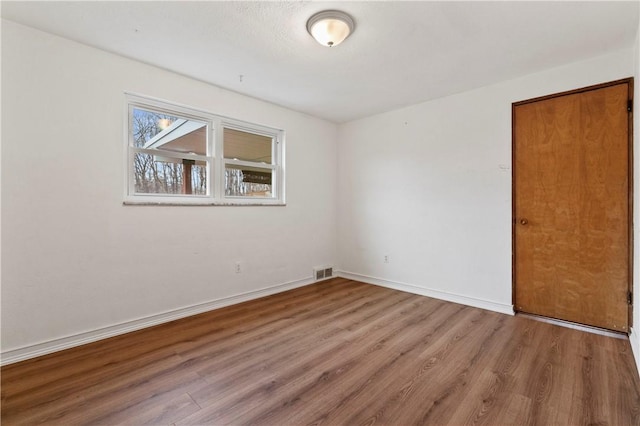 spare room with wood-type flooring