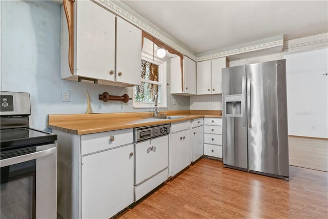 kitchen with white cabinetry, sink, light hardwood / wood-style flooring, and appliances with stainless steel finishes