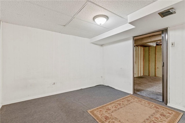 carpeted spare room with a drop ceiling