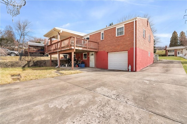 rear view of house featuring a garage and a deck