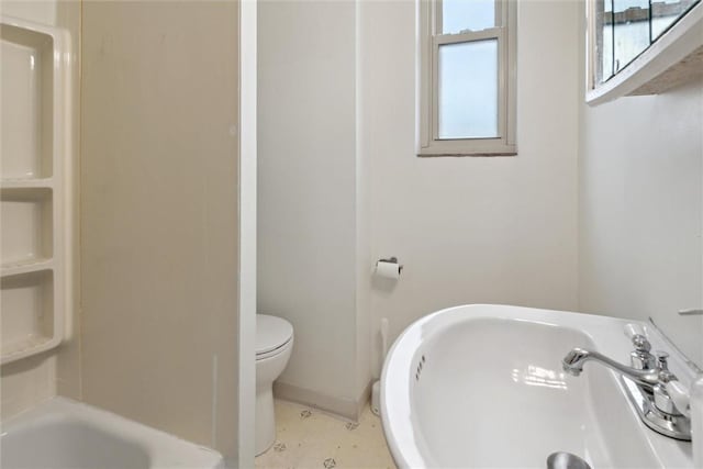 bathroom with sink, a bathtub, and toilet