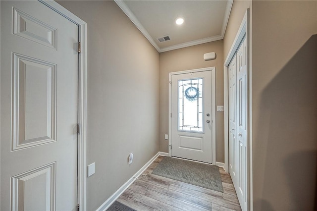 entrance foyer with ornamental molding and light wood-type flooring