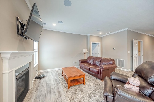 living room featuring ornamental molding and light hardwood / wood-style floors