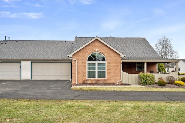 single story home featuring a garage, a front yard, and covered porch