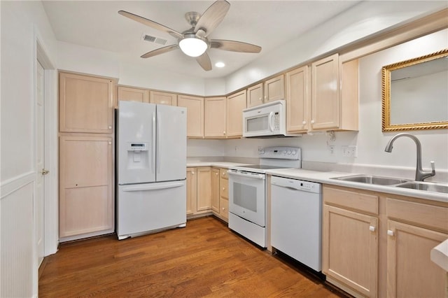 kitchen with sink, light brown cabinetry, and white appliances