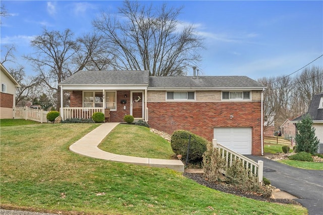 view of front of house with a garage, covered porch, and a front yard