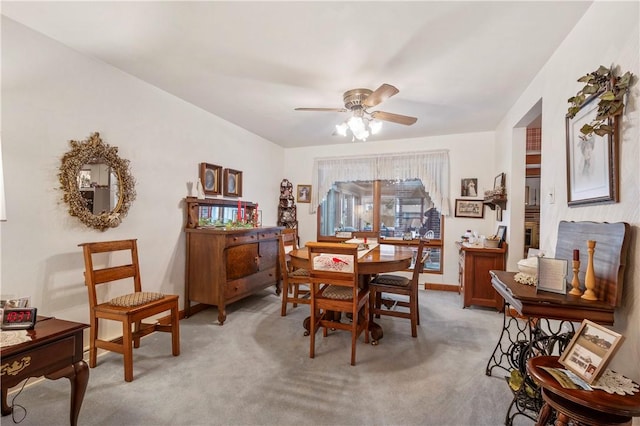 carpeted dining space featuring ceiling fan