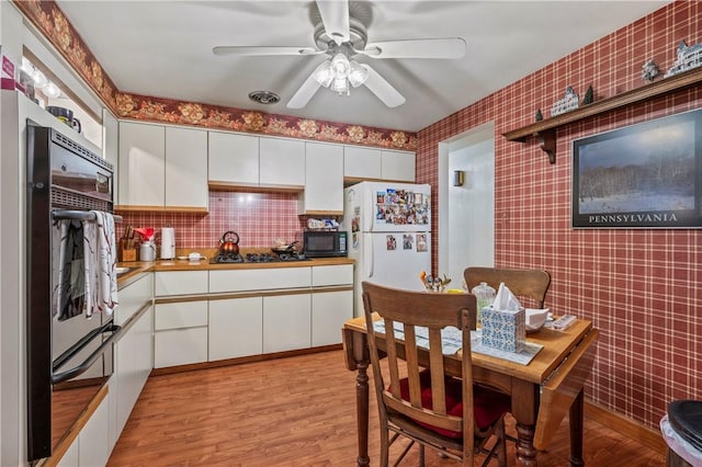 kitchen with black appliances, ceiling fan, light hardwood / wood-style floors, decorative backsplash, and white cabinets