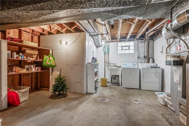 basement with washing machine and clothes dryer and sink