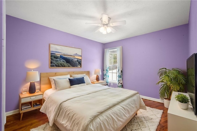 bedroom with dark hardwood / wood-style floors and ceiling fan