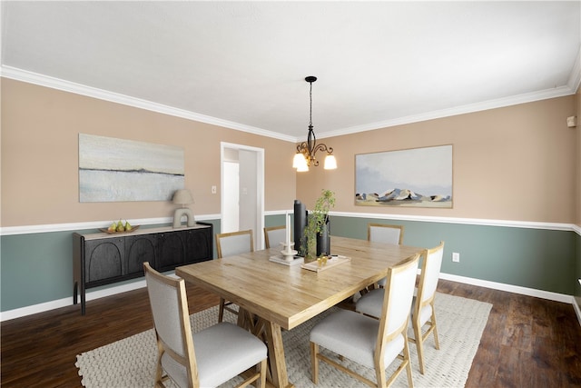 dining space with dark wood-type flooring, ornamental molding, and an inviting chandelier