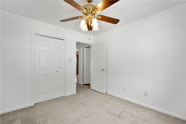 unfurnished bedroom with light carpet, a closet, and ceiling fan