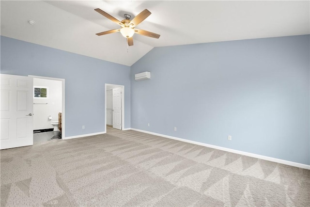 unfurnished bedroom with lofted ceiling, a wall mounted air conditioner, connected bathroom, a spacious closet, and light colored carpet