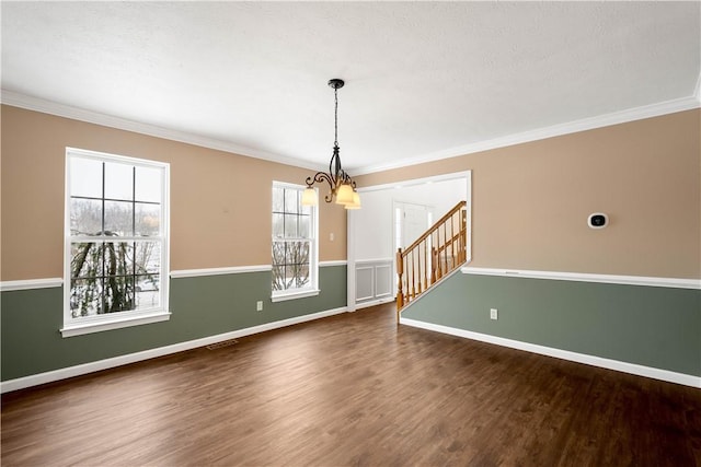 unfurnished dining area with ornamental molding, dark hardwood / wood-style floors, and a chandelier