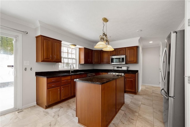 kitchen featuring sink, crown molding, appliances with stainless steel finishes, a kitchen island, and decorative light fixtures