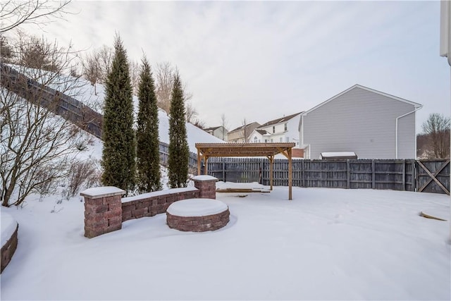 snowy yard with a pergola and an outdoor fire pit