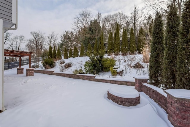 yard layered in snow featuring a pergola