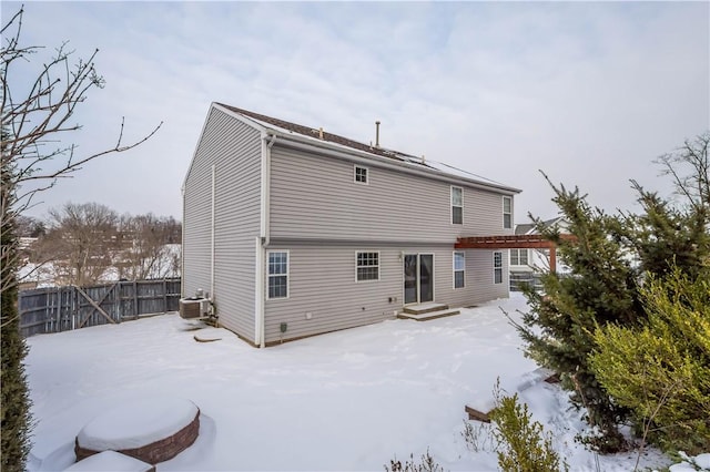 snow covered property featuring central AC unit and a pergola