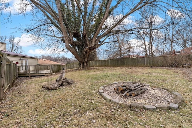 view of yard with a wooden deck and a fire pit